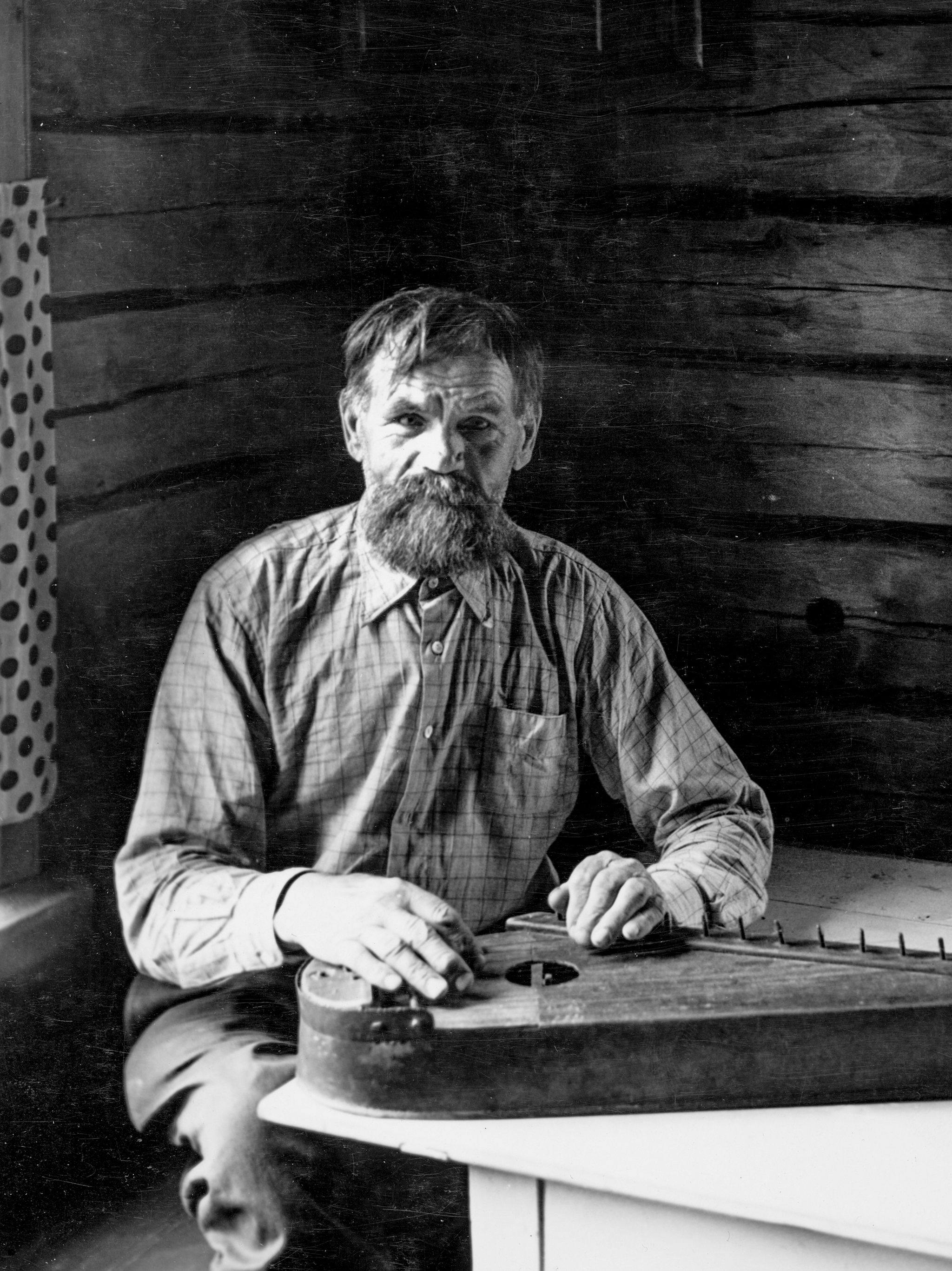 A bear huntter Jeyssei Pyy plays a Finnish zither.<br> <span> 1930 – The Finnish Museum of Photography</span>